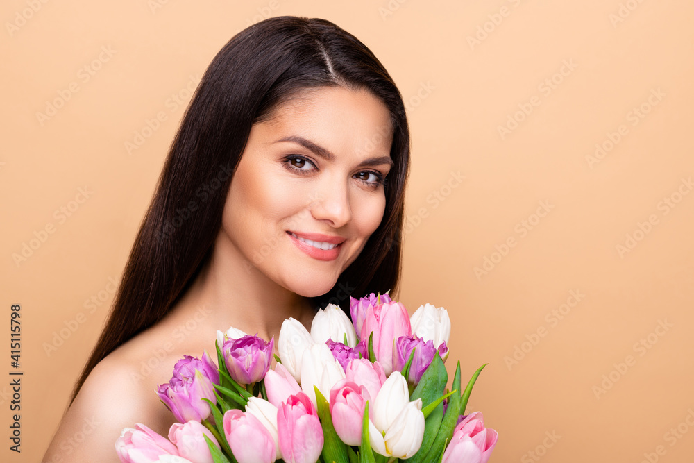 Profile portrait of nice optimistic brunette long hairdo lady hold flower without clothes isolated on pastel beige color background
