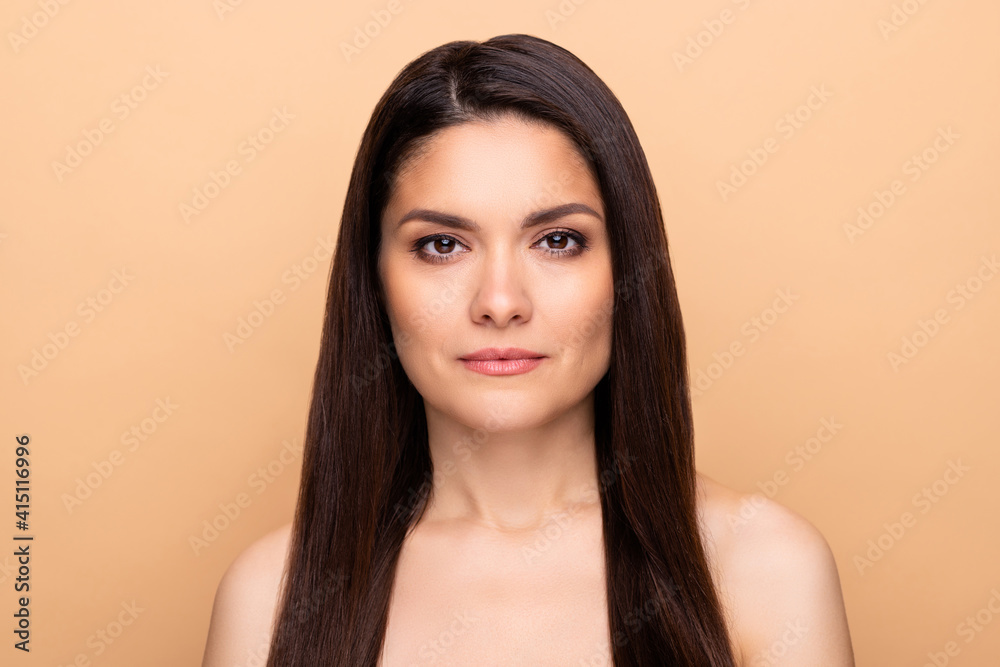 Portrait of nice serious brunette long hairdo lady without clothes isolated on pastel beige color background Portrait of nice serious brunette long hairdo lady without clothes isolated on pastel beige color background