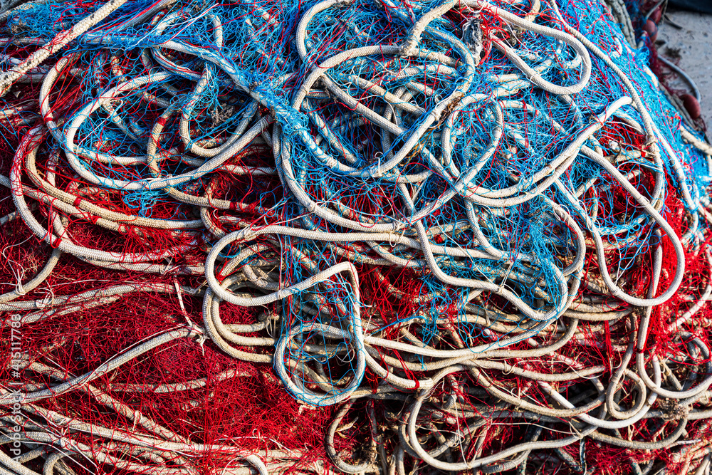 Italy, Apulia, Province of Lecce, Gallipoli. Texture detail of fishing nets in red, white, and blue.
