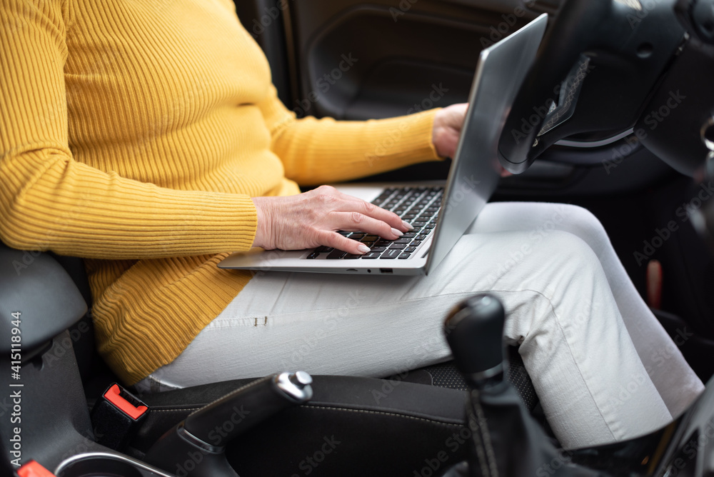 Businesswoman using her laptop in car