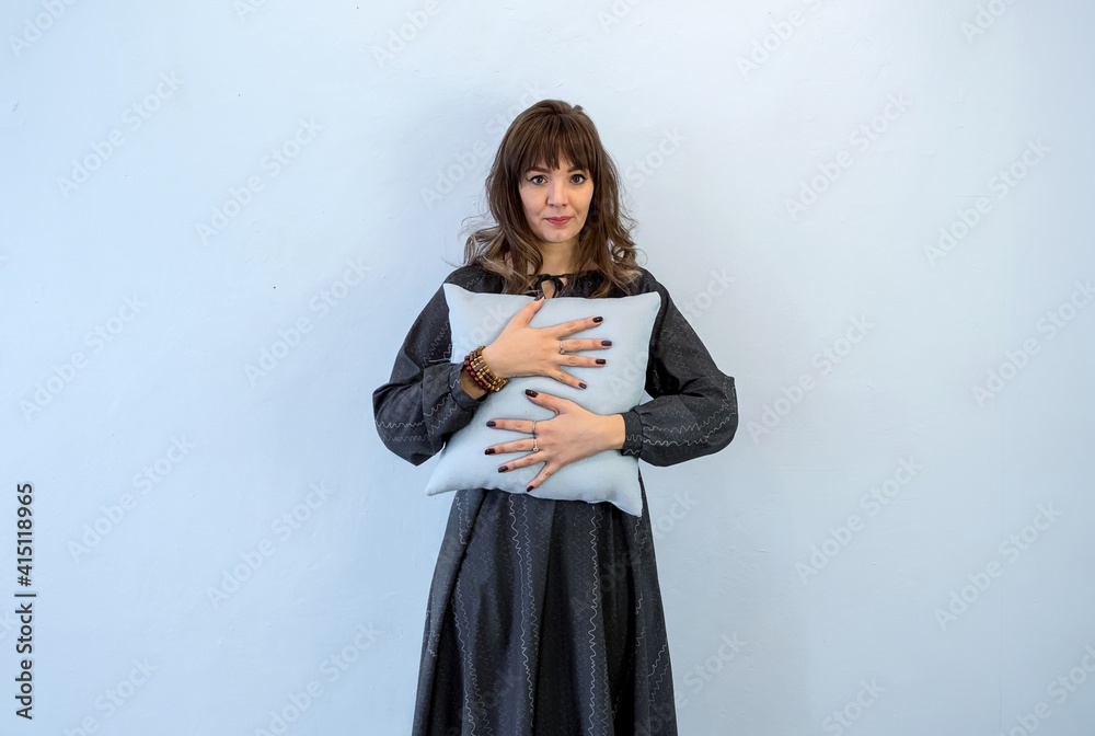 Young woman gently hugs a pillow. The concept of loneliness and tenderness. Young woman gently hugs a pillow. The concept of loneliness and tenderness.