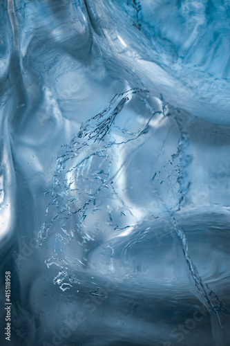 Abstract saturated blue ice. frozen spray of water inside the ice. abstract vertical image.