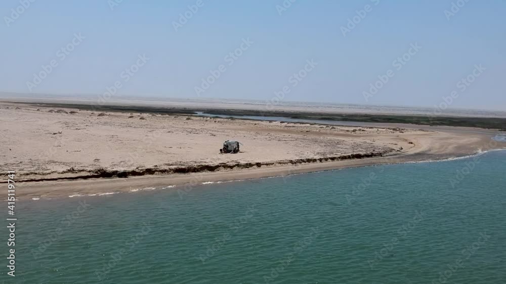 Off road vehicle next to the water at Foz de Cunene the mouth of the Kunene river Angola Aerial Off road vehicle next to the water at Foz de Cunene the mouth of the Kunene river Angola Aerial