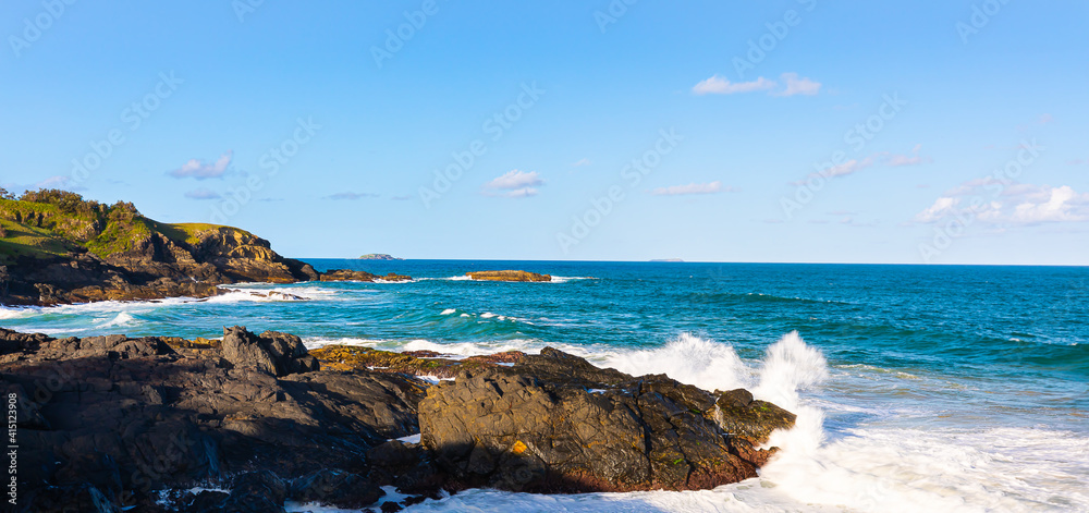 Blue sky over a pacific ocean  with big surf and attractive aqua coloured ocean on the east coast of Australia.