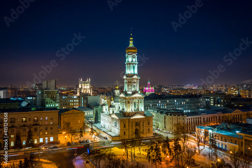 Aerial winter night view to Holy Dormition Cathedral - Uspenskiy sobor, with panorama of city in Kharkiv, Ukraine