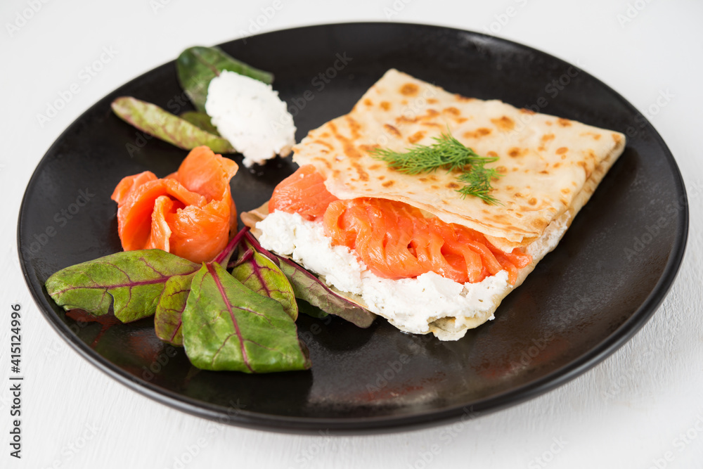 Traditional Russian thin pancakes with filling, red fish and cream cheese Traditional Russian thin pancakes with filling, red fish and cream cheese