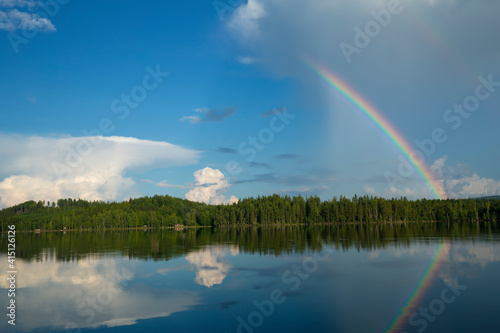Calm lake in sweden with a rainbow reflecting on the surface