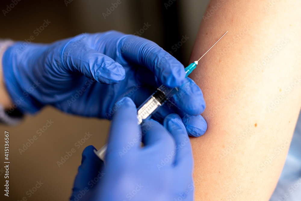 Close up photo of shot of vaccine to a patient's shoulder. Vaccination and prevention against flu or virus pandemic. Close up photo of shot of vaccine to a patient's shoulder. Vaccination and prevention against flu or virus pandemic.