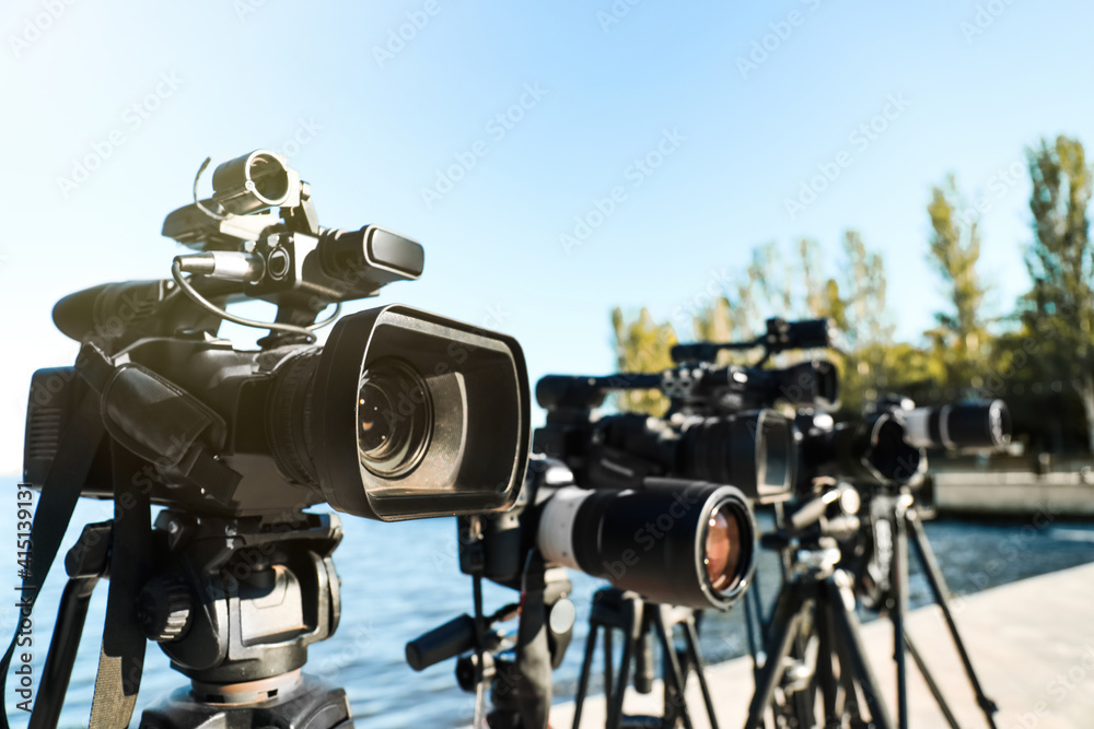 Modern professional video cameras outdoors on sunny day, closeup
