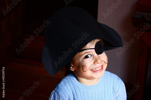 Tableau sur toile A happy young boy wearing a pirate costume. black background.