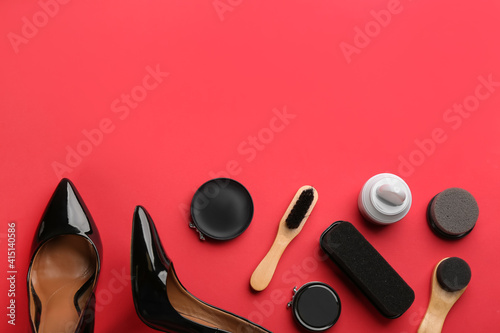 Flat lay composition with shoe care accessories and footwear on red background. Space for text