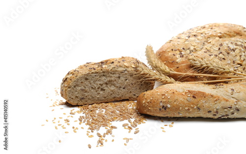 Integral wheat bread and french baguette, sliced loaves with seeds (linseed, oats) and wheat ears grain isolated on white background