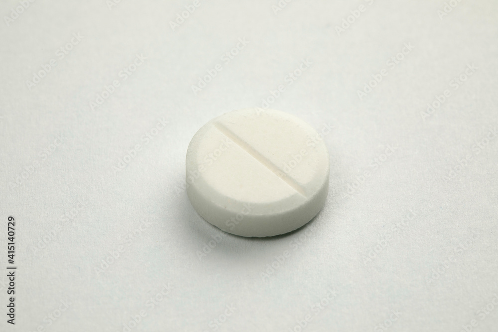 White round pill on white background. Health care concept. White round pill on white background. Health care concept.