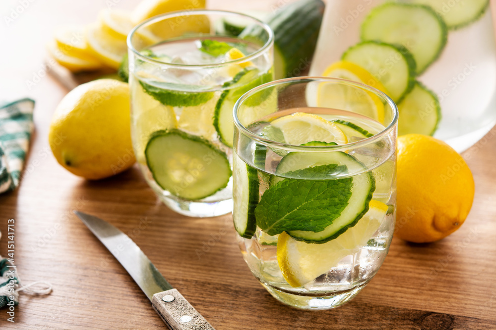 Sassy water or water with cucumber and lemon on wooden table Sassy water or water with cucumber and lemon on wooden table