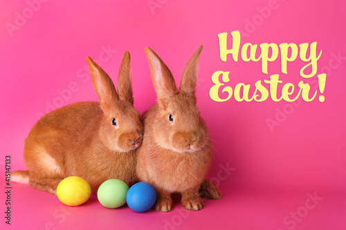 Happy Easter! Cute bunnies and dyed eggs on pink background