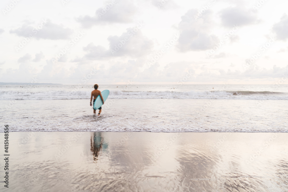 Anonymous man surfer walking in waving sea Anonymous man surfer walking in waving sea