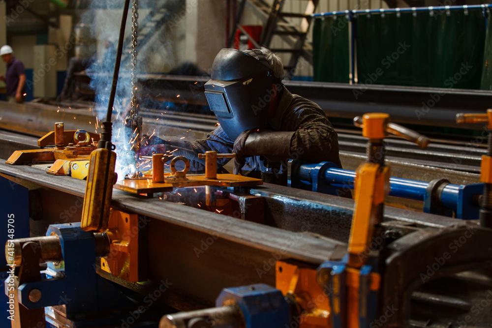 Welder in work. Metal works on machinery production plant. Sparks and smoke. Unsafe work. Welder in work. Metal works on machinery production plant. Sparks and smoke. Unsafe work.