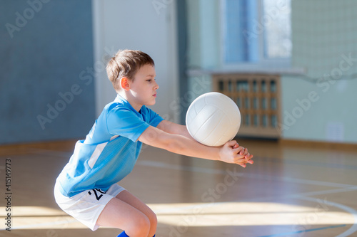 School kid playing volleyball in a physical education lesson. Safe back to school during pandemic concept