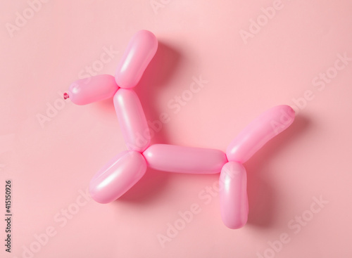 фотография Dog figure made of modelling balloon on pink background, top view