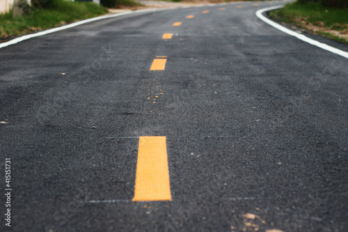 black asphalt winding road transport with white and yellow line