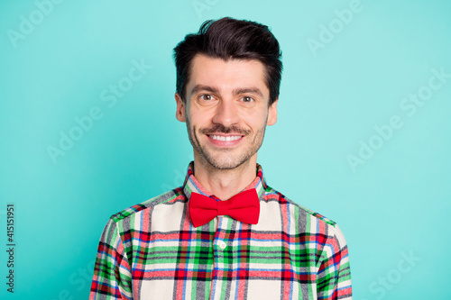 Photo of positive cheerful guy look camera shiny white smile wear plaid shirt bow isolated blue color background © deagreez