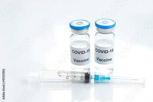 Two Vial of Covid-19 vaccine with syringe on white glass medical background