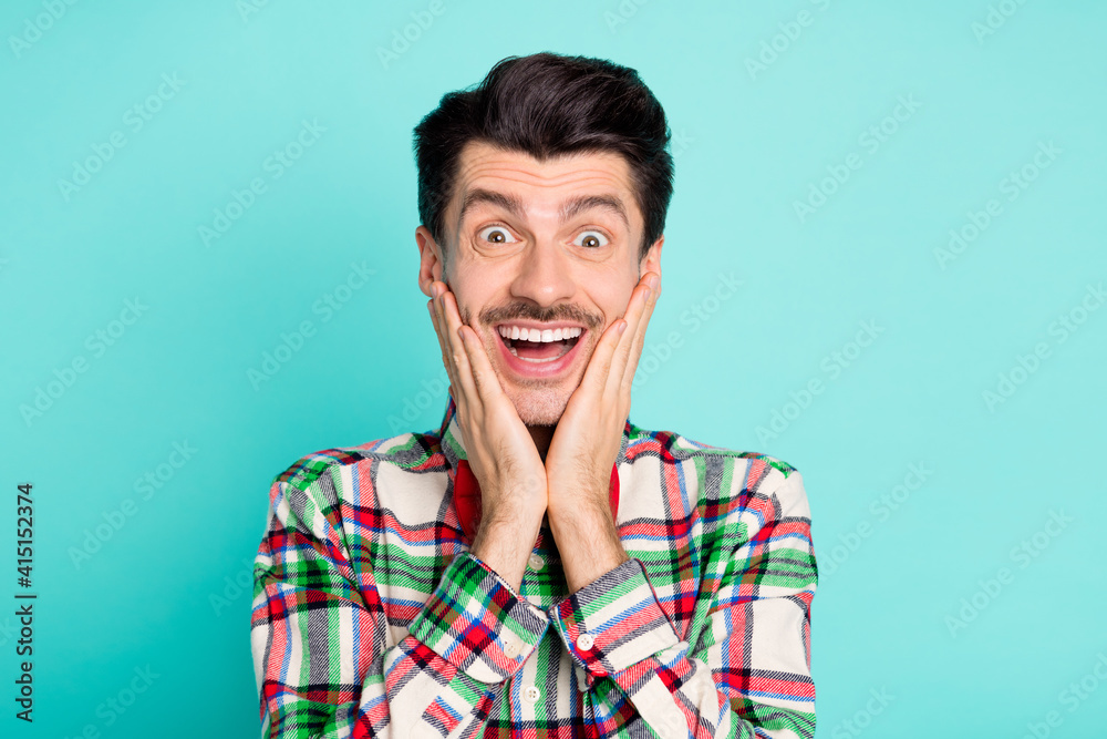 Photo of excited funny surprised guy look hands cheeks open mouth wear plaid shirt bow isolated blue color background Photo of excited funny surprised guy look hands cheeks open mouth wear plaid shirt bow isolated blue color background