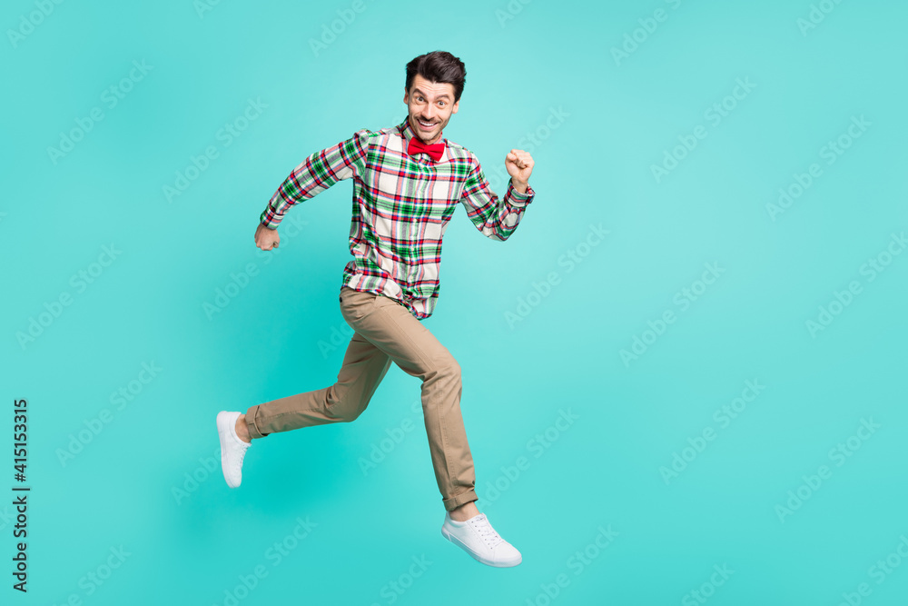 Photo of guy jump hurry run wear checkered shirt bow tie trousers footwear isolated blue color background