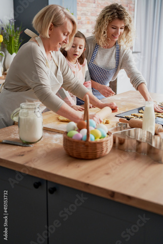 Foto Grandmother teaching granddaughter how to make Easter cake