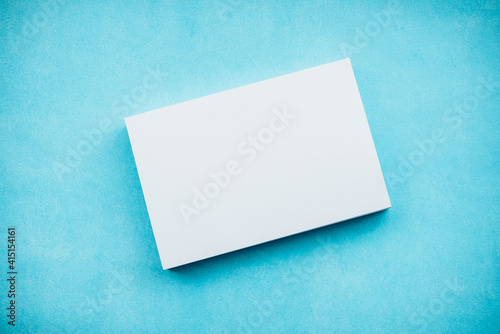 White blank cards in a stack on a blue background. A gentle romantic blank for a postcard. © kulkann