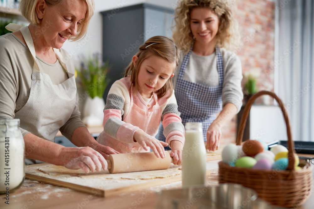 Three generations of women rolling dough Three generations of women rolling dough