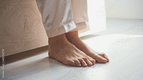 cropped view of awakened barefoot woman getting up from bed © LIGHTFIELD STUDIOS