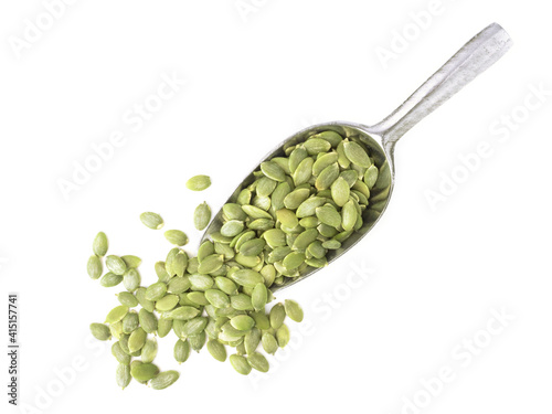 Peeled organic pumpkin seeds in metal scoop isolated on white background for pumpkin seeds can improve health concept.
