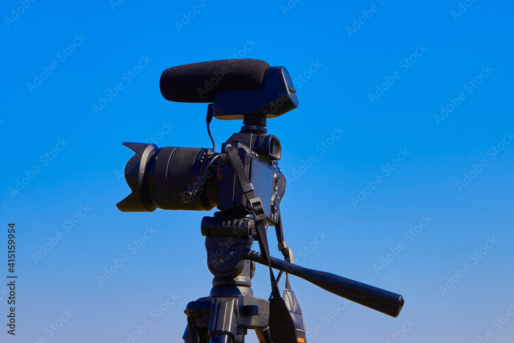 shooting video on camera,photo camera with microphone on sky background shooting video on camera,photo camera with microphone on sky background