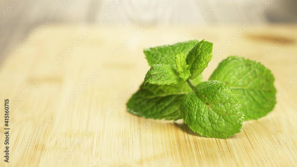 Freshly cut spearmint laid on a small saucer on a wooden surface. Freshly cut spearmint laid on a small saucer on a wooden surface.