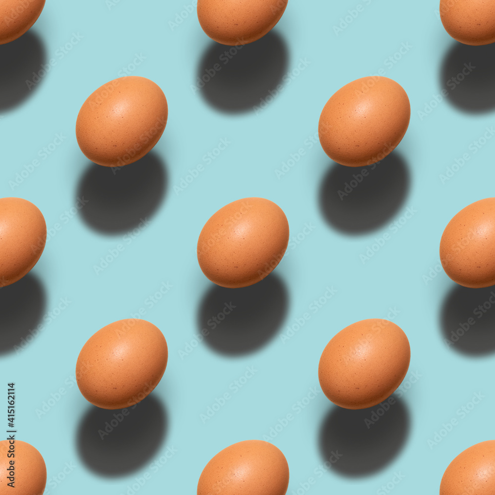 Pattern of brown chicken eggs on a blue background. Minimalism easter, food pattern with hard light and shadows. Pattern of brown chicken eggs on a blue background. Minimalism easter, food pattern with hard light and shadows.