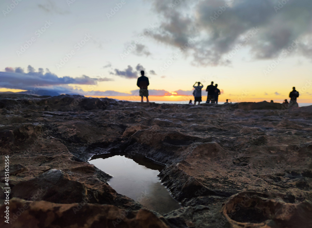 reflects on a puddle in a cliff and the silhouette a group of friends