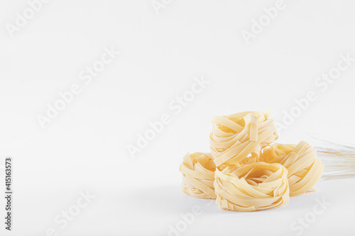 Home made pasta on white background, angle view, soft light, copy space