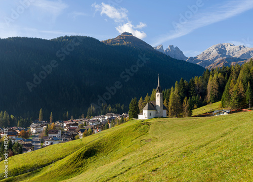 The church, in the background Focobon mountain range in the Pale di San Martino. Caviola, part of Falcade alto in Val Biois, Italy. photo