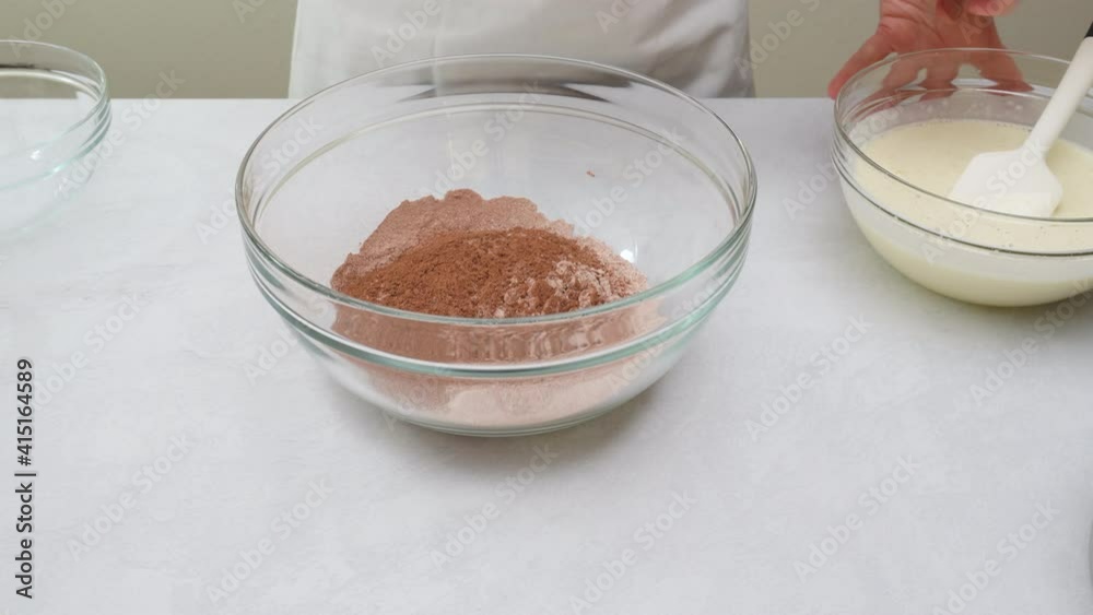 Chocolate cake step by step recipe. Mixing dry ingredients and liquid ingredients together in a glass bowl, close up view Chocolate cake step by step recipe. Mixing dry ingredients and liquid ingredients together in a glass bowl, close up view