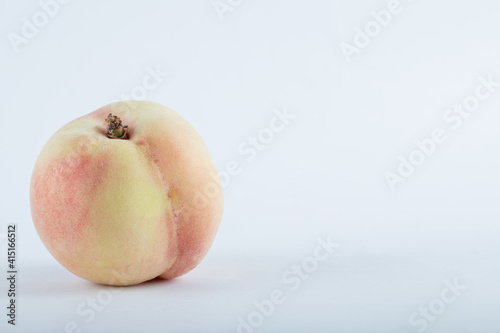 Single fresh peach on a white background