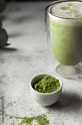 prepared matcha tea in a clear glass. a delicious drink made from Japanese green tea powder. vertical position