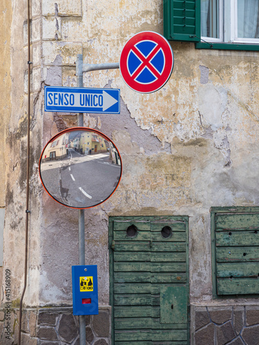 Old town house and traffic signs. Predazzo in valley Val di Fiemme, in the Dolomites Italy. photo