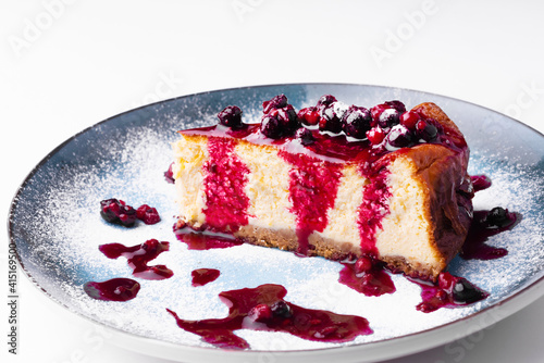 Photo of tasty cheese cake with berries over white background.