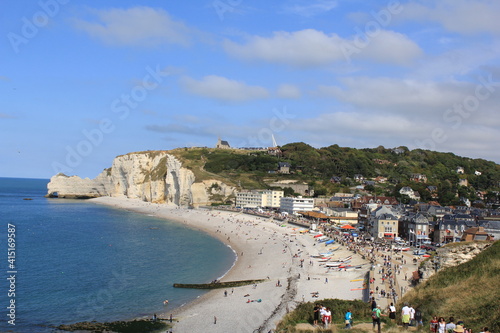 a beautiful sea landscape at the french coast in normandy in summer with beautiful white cliffs and a beach and village along the bay in le treport photo