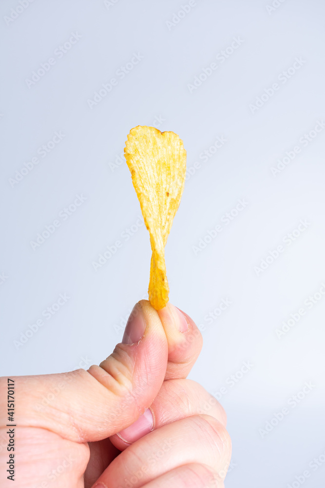 Potato chips in hand on white background Potato chips in hand on white background