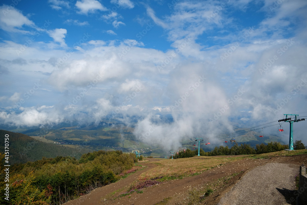 Panorama view of clouds and chair lift in Carpathian Mountains