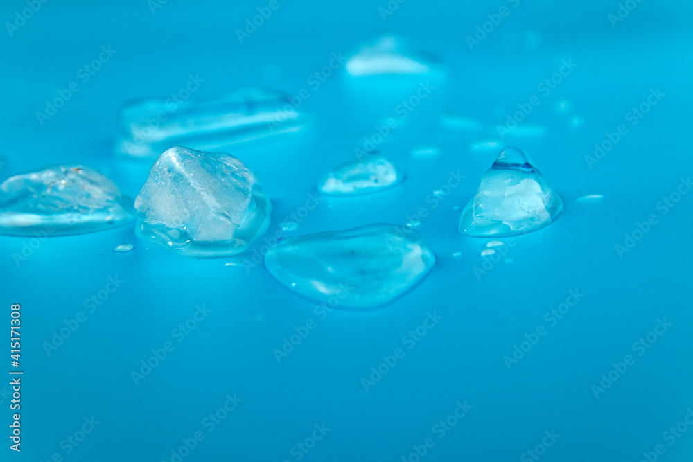 Ice melts against a blue background. Ice melts against a blue background.