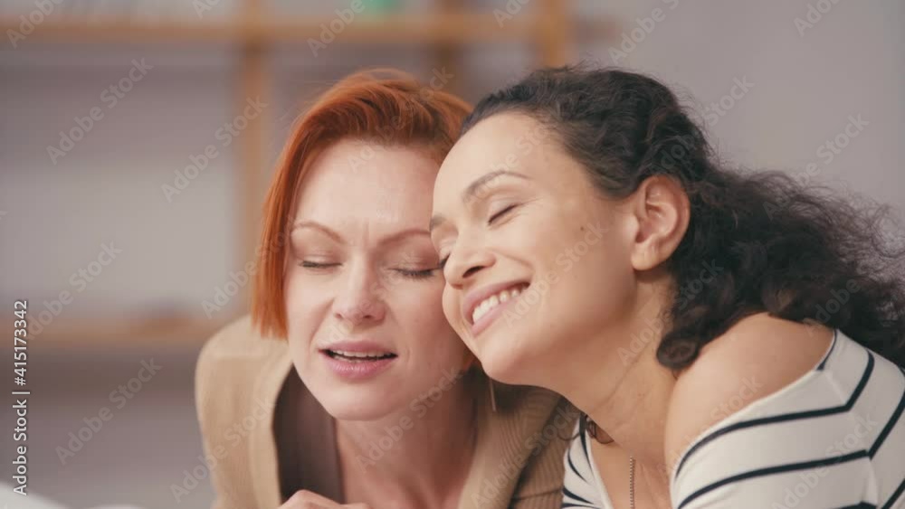 happy interracial girlfriends with closed eyes smiling at home happy interracial girlfriends with closed eyes smiling at home