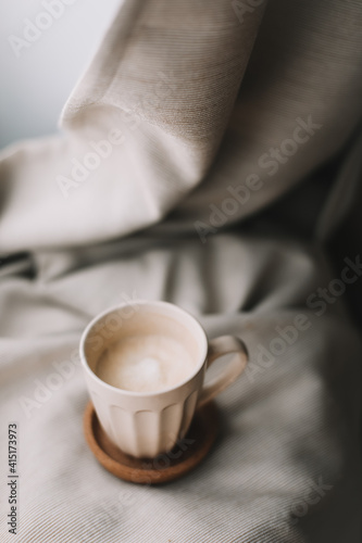 Cup of coffee with milk on beige plaid. Flat lay  top view still life morning breakfast. Comfort  cosiness and warmth concept. Photo in light pastel colors